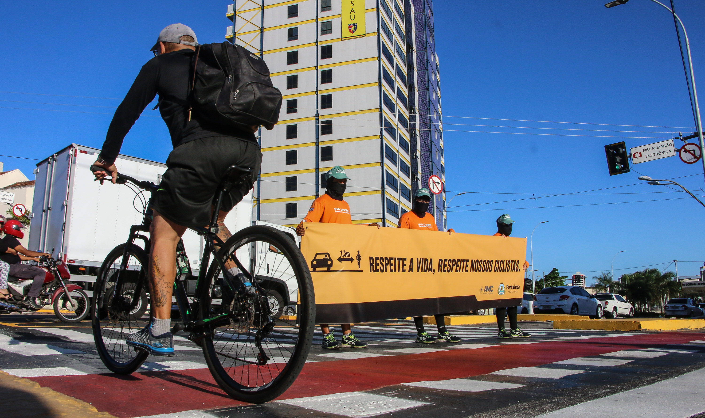 agentes da amc abrem uma faixa com as frases: respeite a vida. respeite nossos ciclistas na avenida aguanambi